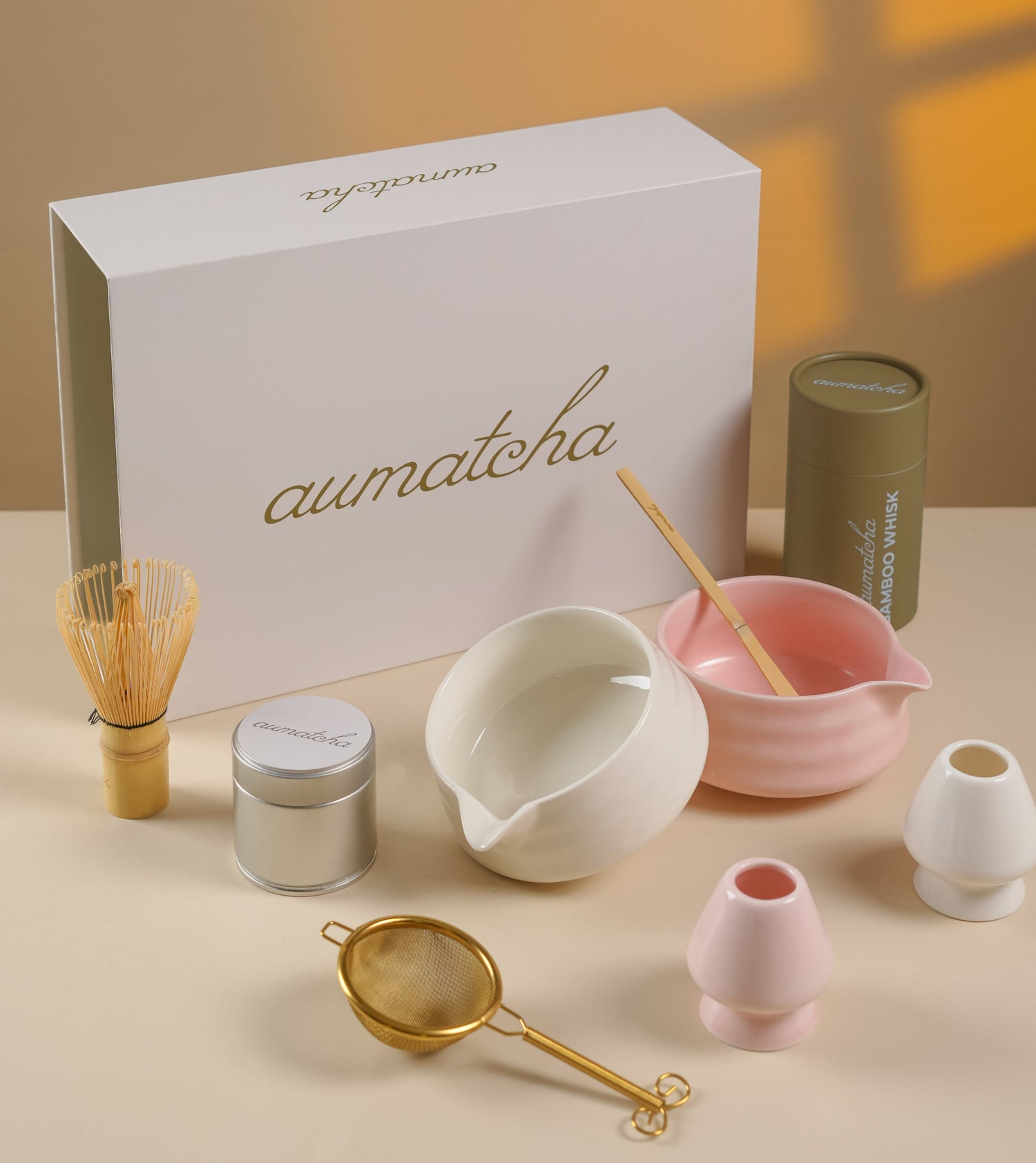 Tea-making set with 'aumatcha' branded box on a beige surface
