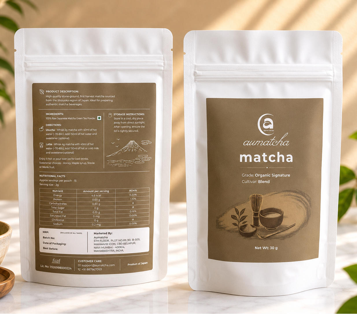 Two packages of aumatcha matcha on a light surface with a blurred background