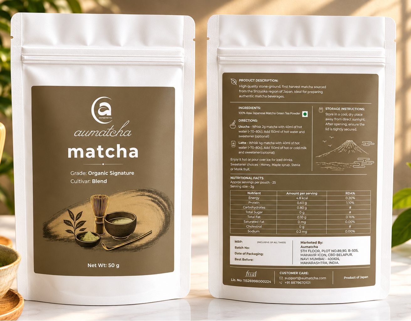 Two packages of aumatcha matcha with a background of greenery
